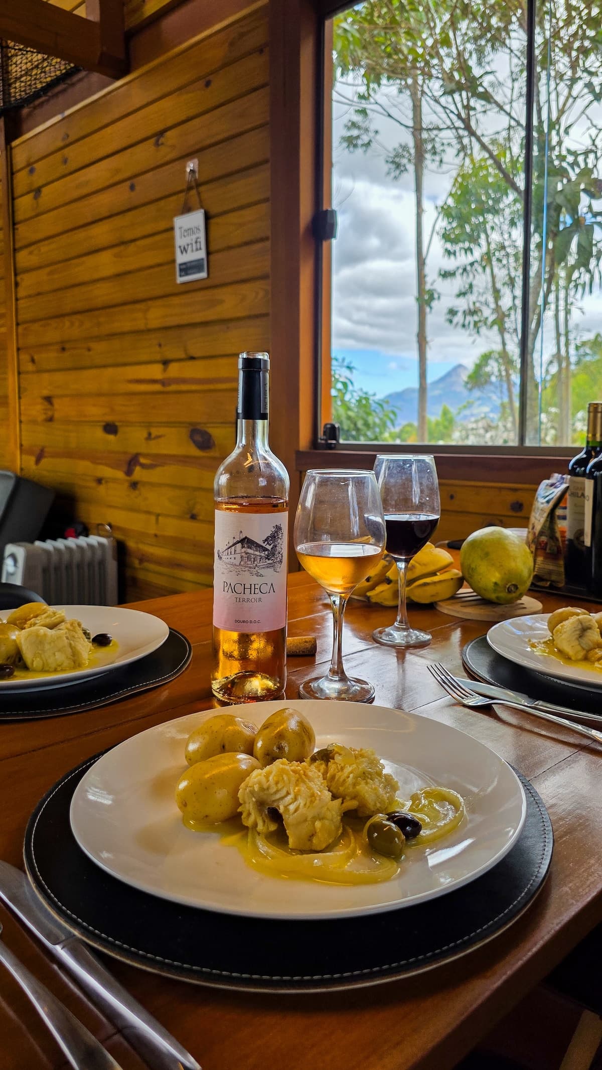Mesa posta com vinho e vista para a serra