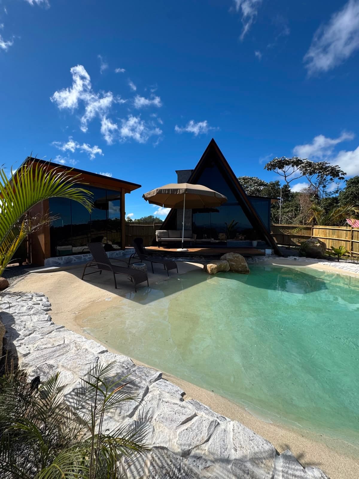 Piscina de borda natural com o chalé em A ao fundo