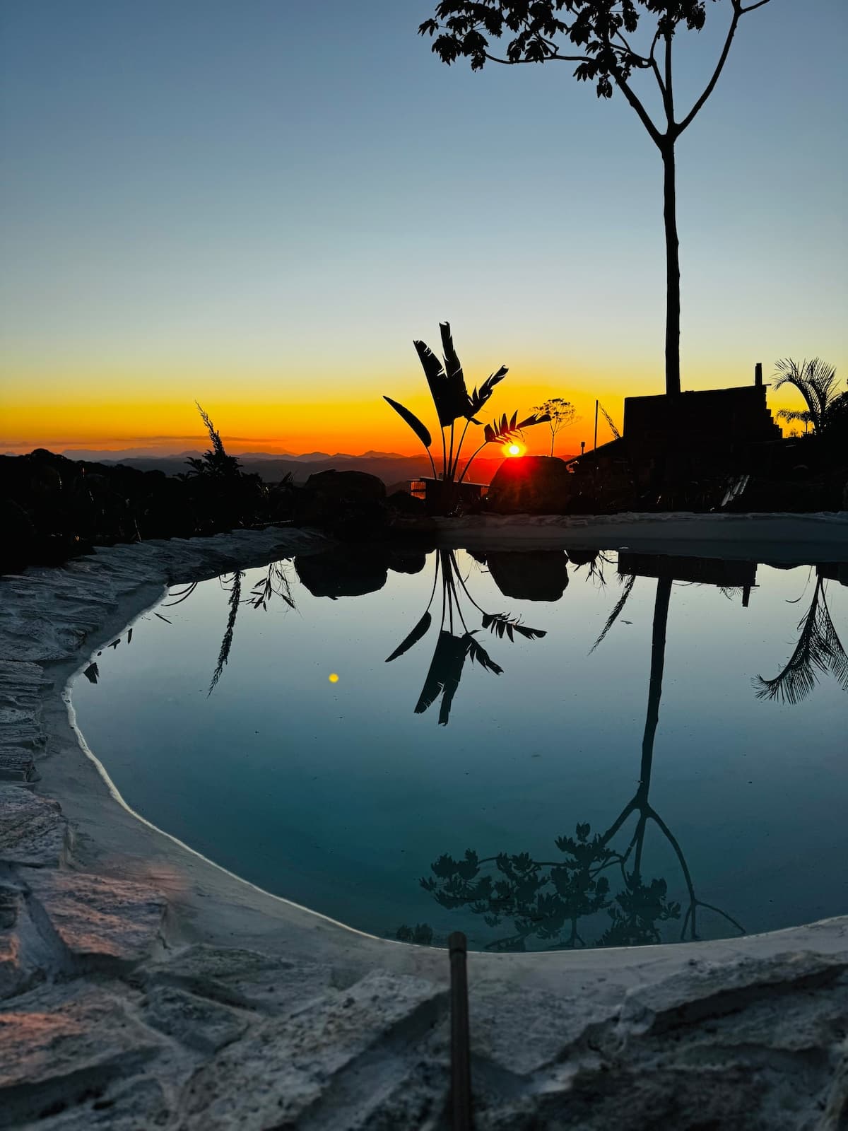 A piscina iluminada ao pôr do sol