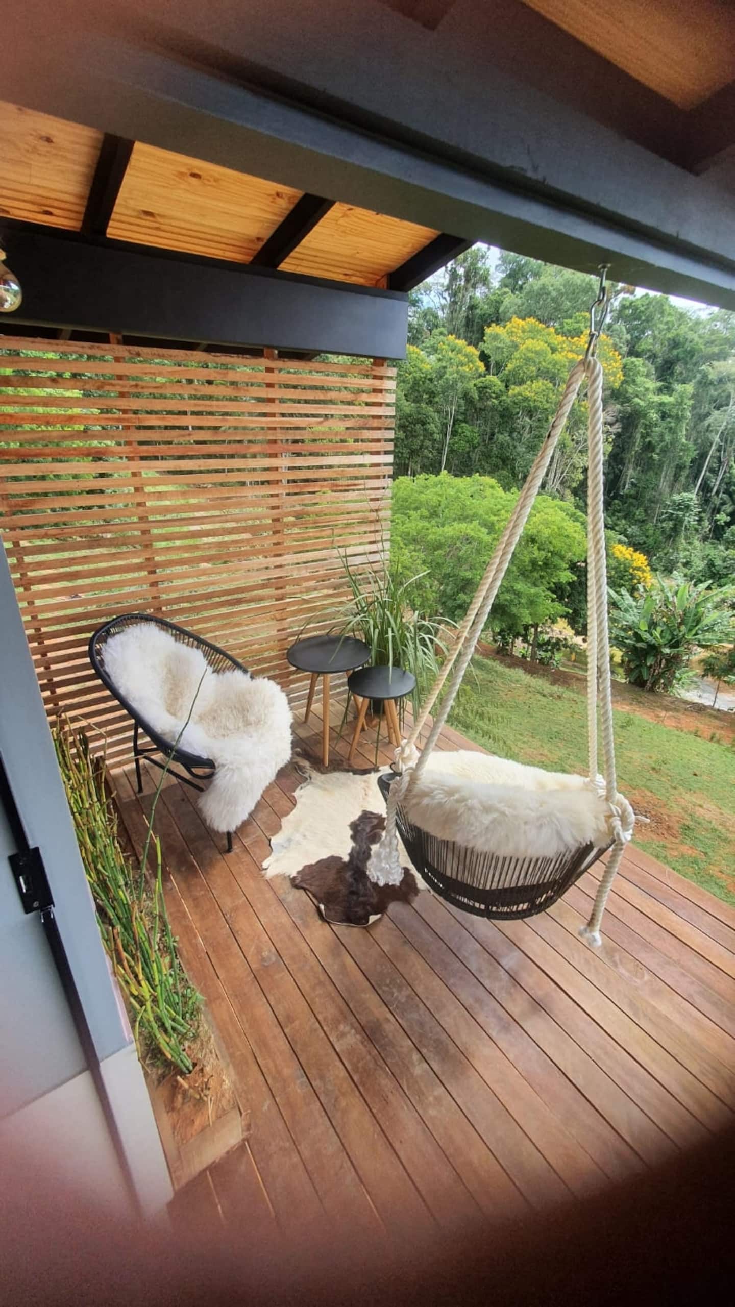 Deck com cadeira de balanço e vista para o vale